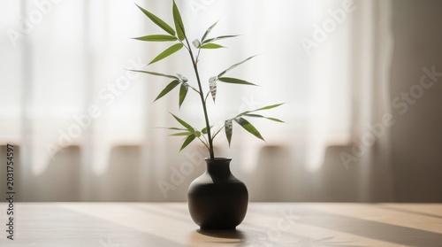 A single bamboo stalk in a dark vase sits on a wooden table, bathed in soft, natural light from a window, creating a serene, zen-like mood.