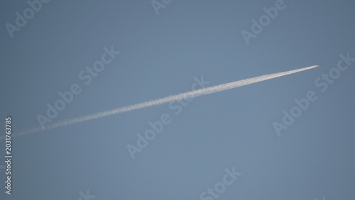 Foto Commercial airplane flying high in a clear blue sky
