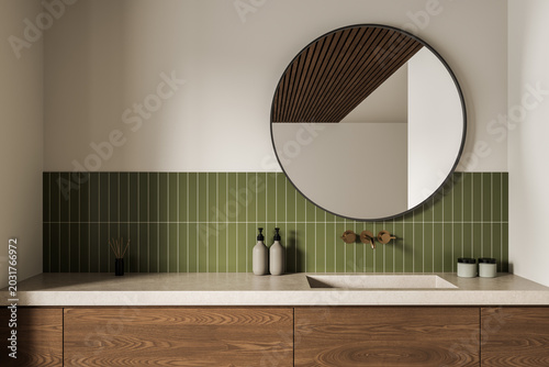 Canvastavla Modern bathroom interior with round mirror, green vertical tiles, wooden vanity, minimal accessories, warm light ambiance