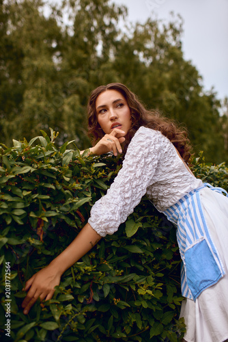 Fotografie Enchanting garden scene with a beautiful woman embracing the magic of nature
