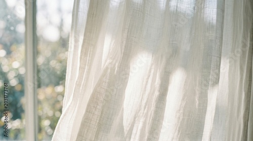 Soft white curtains glowing with gentle morning light, sheer fabric catching sun and shadows to create a peaceful, airy and calming atmosphere by the window


