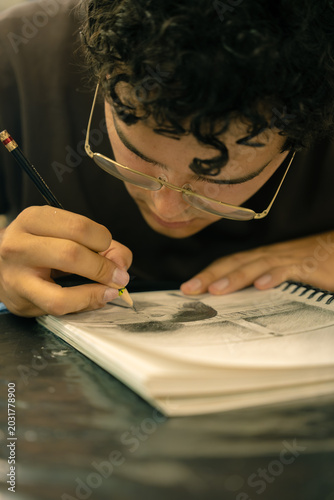 фотографія Person concentrating while sketching portrait in sketchbook