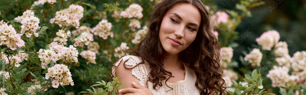 Fototapeta premium Enchanting woman surrounded by blooming flowers in a serene outdoor park setting