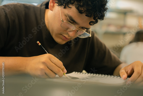 Schilderij op canvas Young student artist drawing in sketchbook with pencil