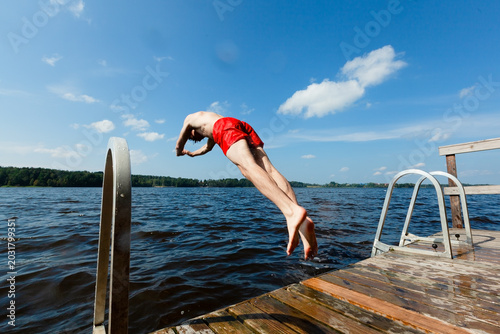 Photos Guy dives off dock into calm lake in free fall on warm summer day