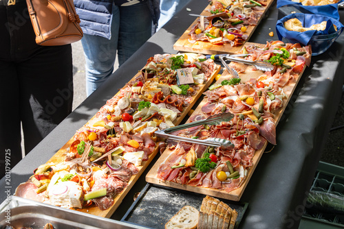 Canvastavla Buffet traiteur avec planches de charcuterie, fromages et tapas lors d’un événement convivial en extérieur
