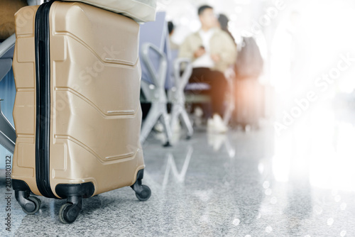 Hard shell suitcase positioned beside seating area in airport