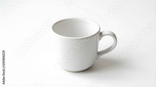 Simple white ceramic coffee mug with a curved handle captured in a bright studio photograph showcasing minimalist design aesthetics and clean lines perfect for beverage service in a home setting