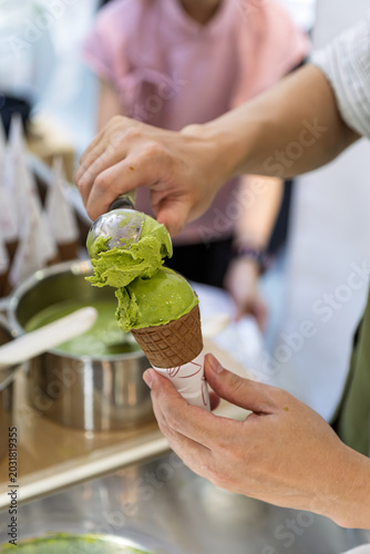 sales clerk making longjing green tea flavor soft serve ice cream