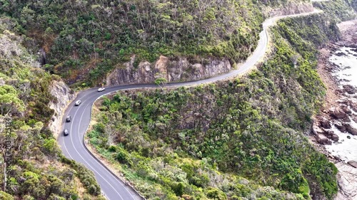 Passenger cars driving on Great Ocean road scenic B100 highway in Victoria – aerial view.