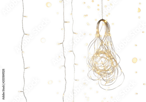 Hanging led fairy lights with a tangled bundle of glowing white bulbs against a solid black background, vertical light strands