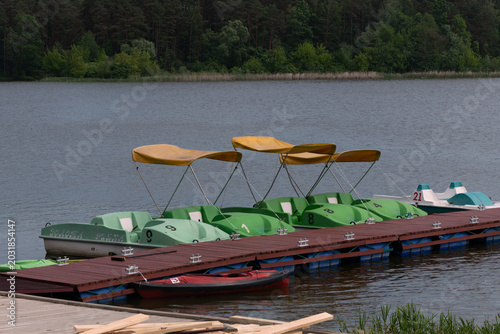 Pedal boats docked on a lake pier