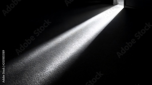 Bright beam of light streaming through open doorway into dark room creating high contrast shadows on floor representing hope opportunity and new beginnings in life