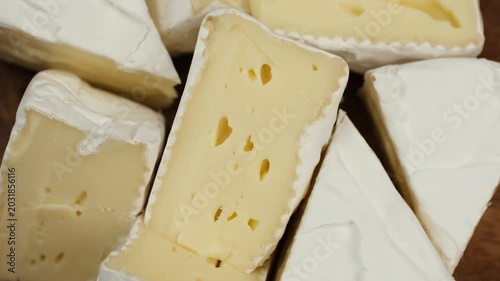 White soft moldy cheese brie or camembert on wooden plate, rotation