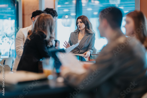 Fotografie A young businesswoman leads a discussion with colleagues during an informal meeting