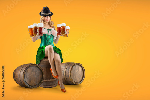 Photos Oktoberfest girl waitress sitting on a wooden barrel