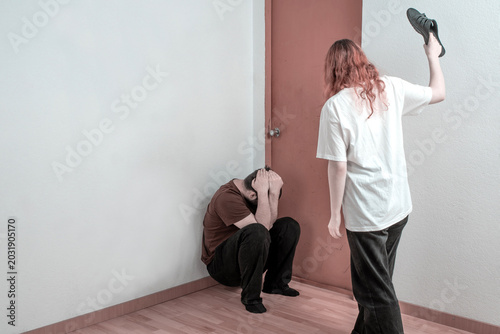 Cuadro en lienzo Female aggressor raising a shoe over a frightened man, relationship violence, coercive control and intimidation indoors
