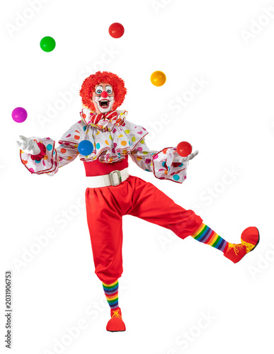 Funny juggler clown juggling balls in the circus, man entertainer as Joker in a suit and wig, with clown whiteface makeup. Trickster, jester, pantomime, mime, and a professional actor at events