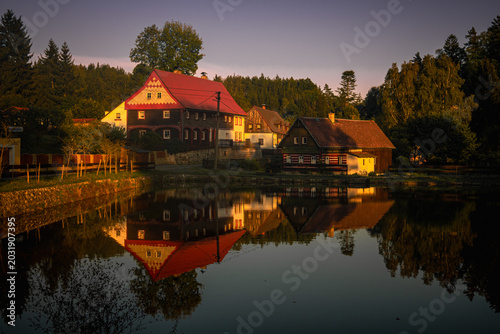 Photos Traditional timbered houses reflected in a pond in Polesi , Lusatian Mountains