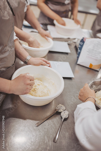 Konstfotografi Hands are mixing dough for sourdough bread and pizza in a busy bakery kitchen du