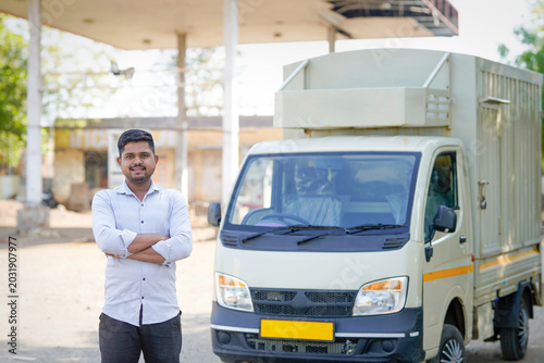 young indian man standing with transport vehicle