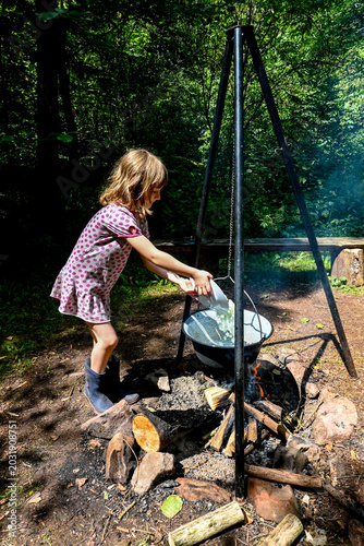 Cooking goulash in a large outdoor cauldron over a campfire