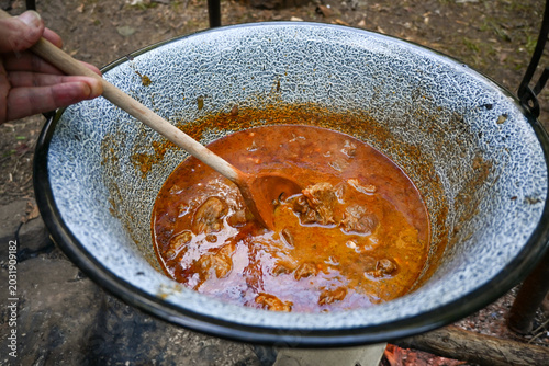 Close-up of homemade goulash cooking in a rustic outdoor cauldron