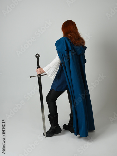 Schilderij op canvas full length portrait of female red head model wearing medieval fantasy warrior historical costume with blue cloak