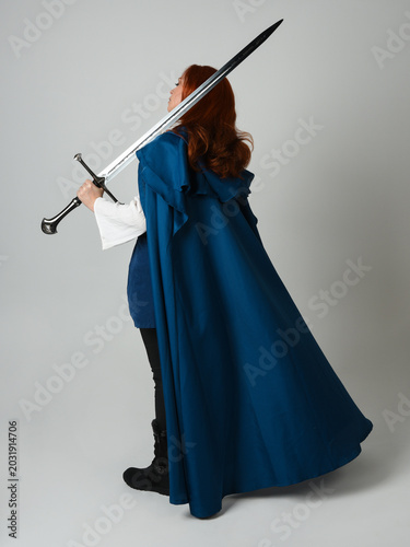 Schilderij op canvas full length portrait of female red head model wearing medieval fantasy warrior historical costume with blue cloak