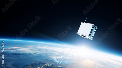 White nano satellite flying above curved Earth horizon in deep space, futuristic orbital communication, climate monitoring, remote sensing and modern aerospace innovation concept n