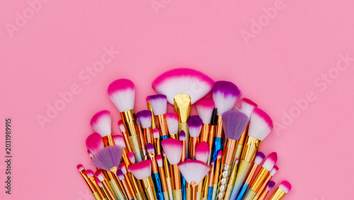 Fotografie Collection of makeup brushes arranged on a pink background showing different sha