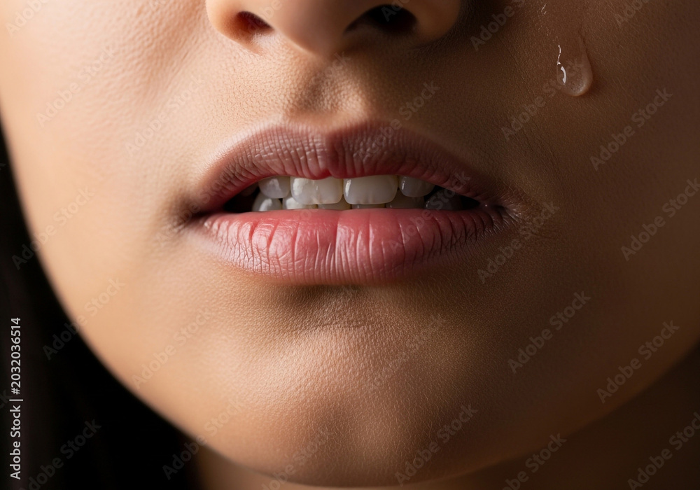 Obraz premium Close-up of woman's lips with glossy lipstick and subtle highlights on skin.