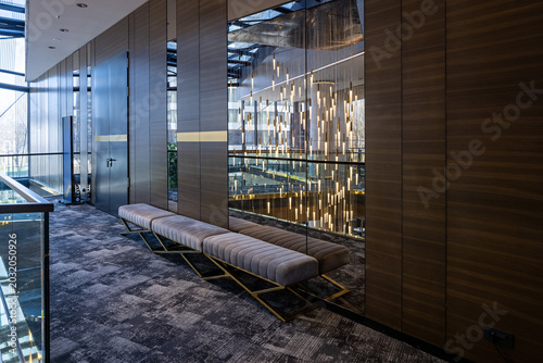 Schilderij op canvas Elegant hotel corridor with upholstered benches and decorative lighting reflecti