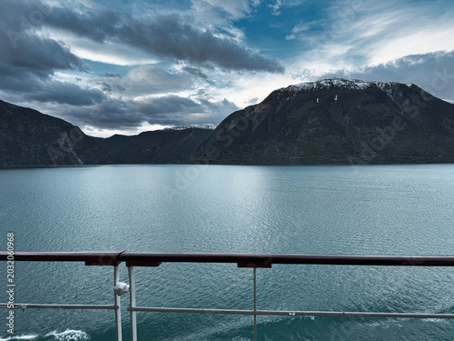 Moody Norwegian Fjord View From Cruise Ship Deck With Mountains and Cloudy Sky