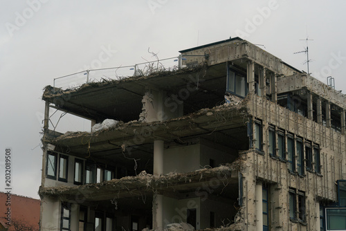 This is an old,wrecked concrete building before its complete destruction, shot from a public place.
