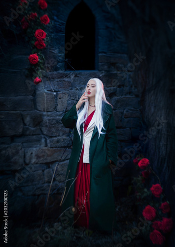 Gothic fantasy vampire woman in dark green cloak elegant portrait at twilight.