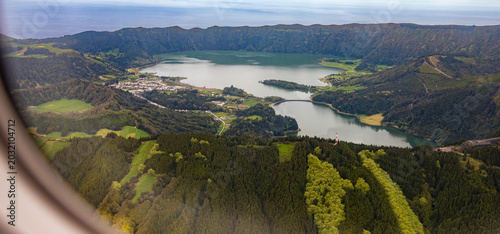 High-angle aerial window view of Lagoa das Sete Cidades twin crater lakes and surrounding lush volcanic mountains on Sao Miguel Island in the Azores.