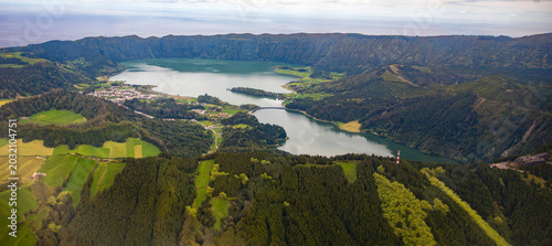 Aerial view of the Sete Cidades volcanic crater lakes, Lagoa Azul and Lagoa Verde, surrounded by green forests on Sao Miguel Island, Azores, Portugal.