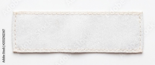 .A blank white rectangular textile clothing label with stitched borders, lying flat on a pure white background. Minimalist, high details of fabric texture, soft lighting, perfect for mock up, photorea