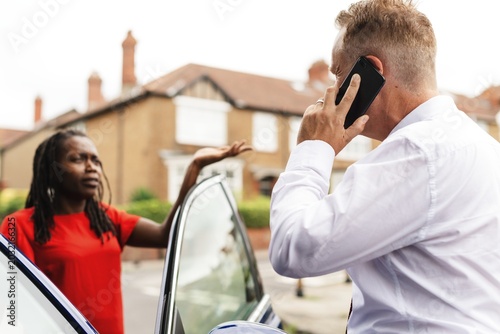 Foto A man in a white shirt talks on a phone by a car