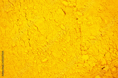 Obraz na plátně Close-up macro background of bright yellow powdered spice with granular texture, ideal for food, seasoning, and abstract backdrop use