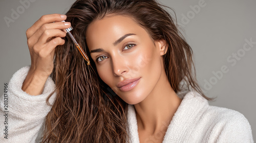  Woman applying hair care serum with a dropper, nurturing scalp and roots for strong, healthy, and beautiful hair, embracing beauty routine and wellness