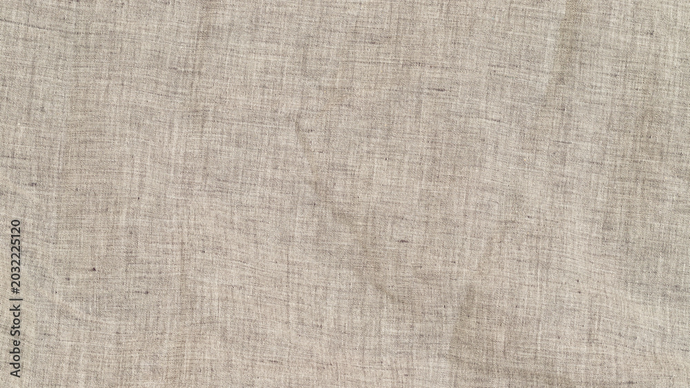 Fototapeta premium Close look at textured fabric with natural fibers in neutral tone during bright daylight