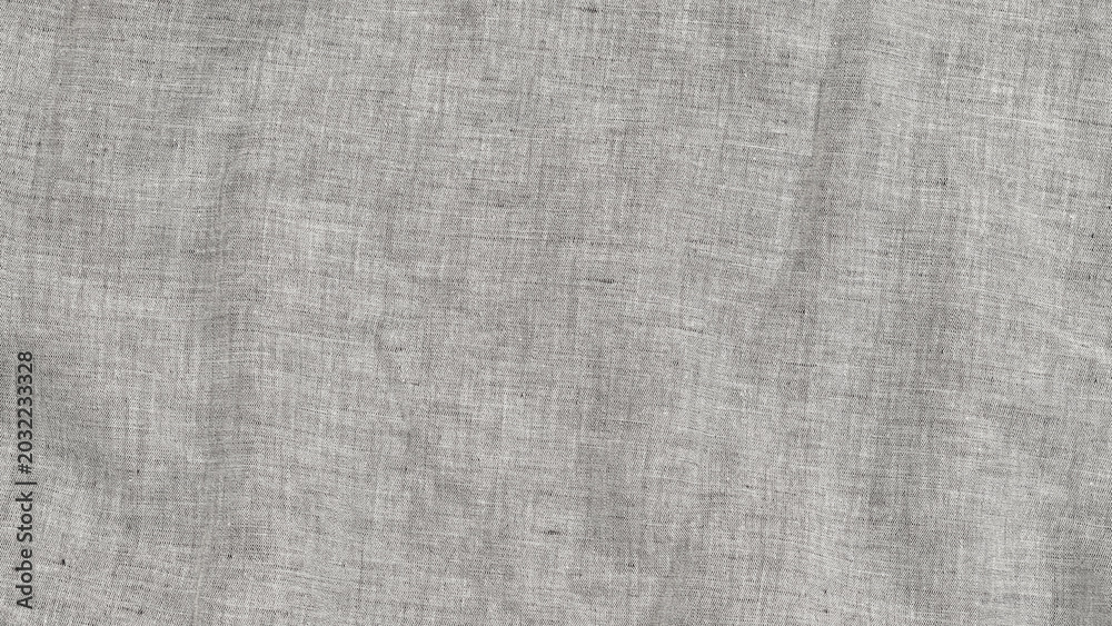 Fototapeta premium Light gray linen fabric with texture displayed on a flat surface in natural light