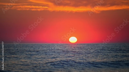 Romantic sunset over the sea with dramatic orange clouds and serene horizon, cinematic 4K.