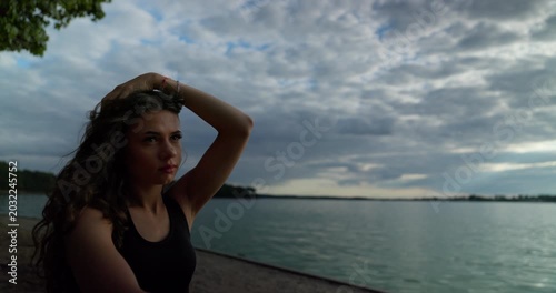A contemplative woman finds herself by the beautiful lake, enjoying the peaceful dusk hours
