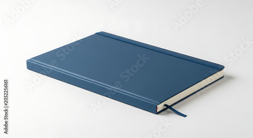 A closed blue notebook with a ribbon bookmark lying on a white surface in a studio setting scene ai generated