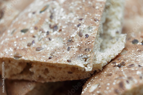 Foto Extreme macro close-up of rustic whole wheat flatbread torn pieces with mixed se