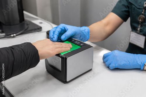 Fingerprint scanning with a biometric scanner for digital identity verification and modern security system, close-up view