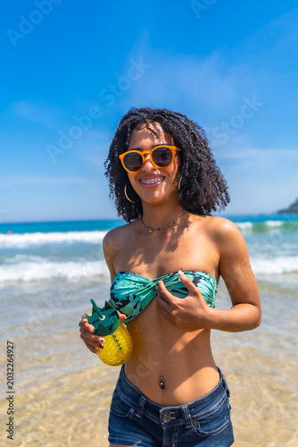 Young woman enjoying tropical beach vacation with drink